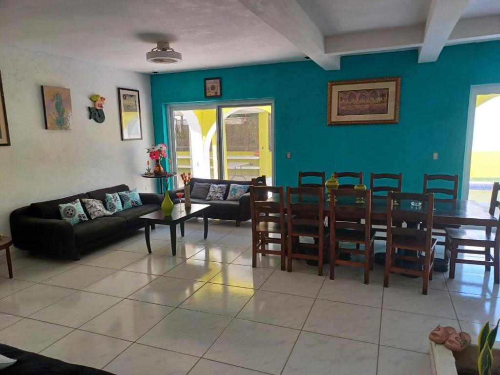 un soggiorno con divano, tavolo e sedie di Chalet san marino a Colonia La Providencia