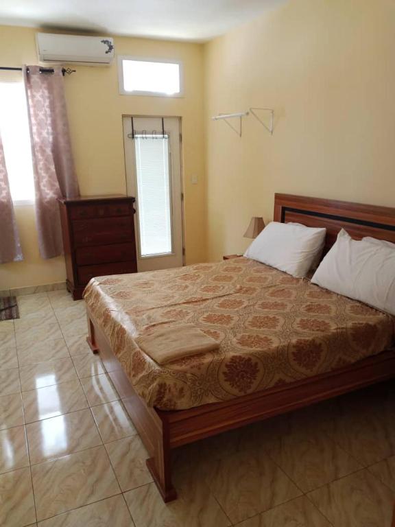 a bedroom with a large bed and a window at Résidence Sotour in Dakar