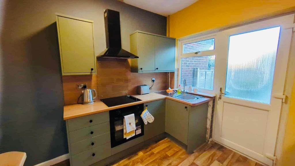 una cucina con lavandino e piano cottura di The Smart Stay - sleeps 5 Wigan central location a Wigan