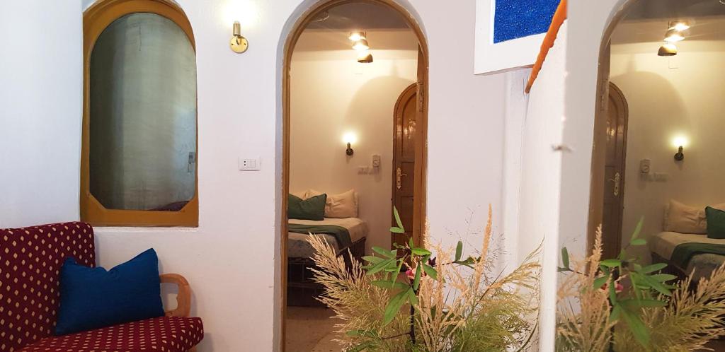 Al AqālitahにあるHabuHeritageHomeStayInLuxorのアーチ型の窓2つ、リビングルームが備わる客室です。