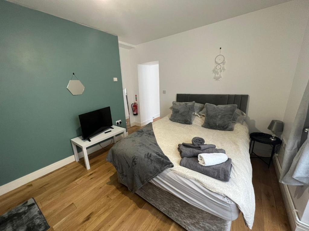 um quarto com uma cama grande e uma televisão em Dream Weaver Apartment em Swansea