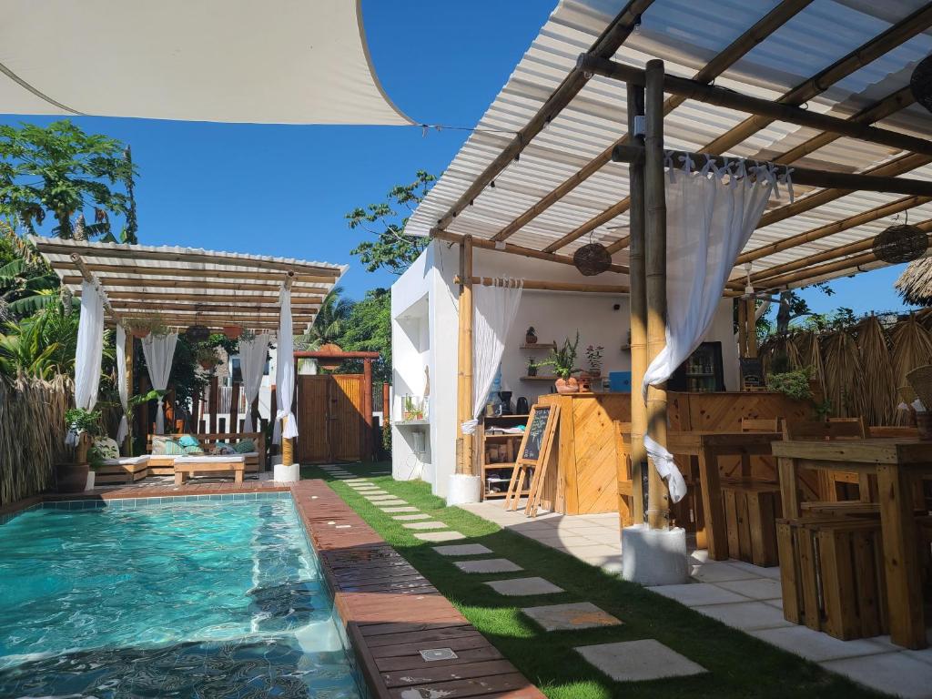 a pool with a pergola next to a house at Wander Boutique Hotel in El Paredón Buena Vista