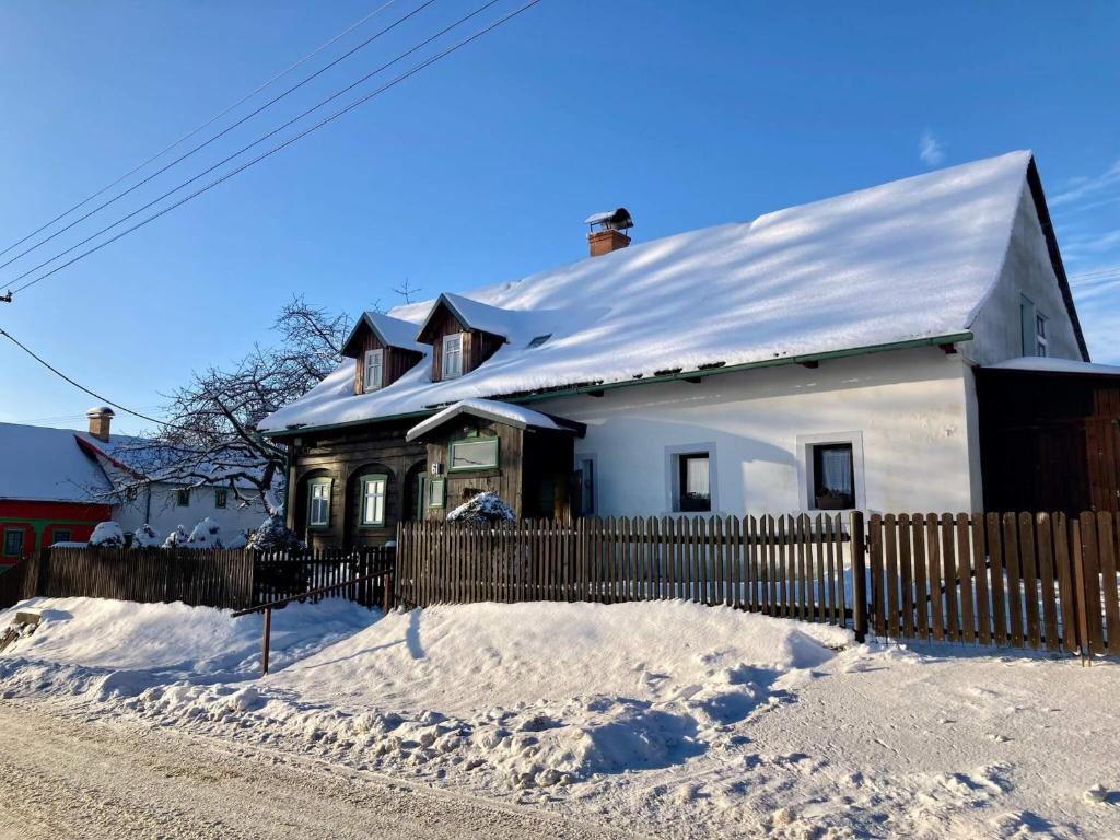 Casa blanca con techo cubierto de nieve en Chalupa na Valech, en Krompach