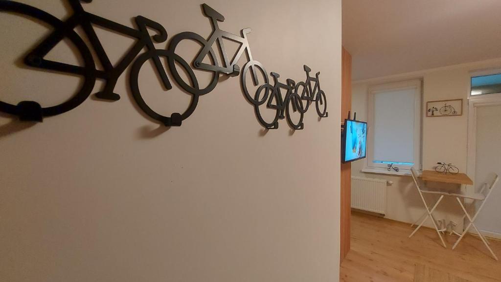 ein Zimmer mit einer Gruppe von Fahrrädern, die an einer Wand hängen in der Unterkunft Apartament z rowerami in Misdroy