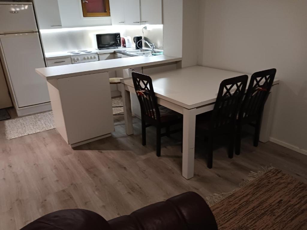 uma cozinha com uma mesa e cadeiras numa cozinha em Apartment Reki em Rovaniemi
