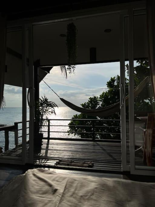 a bedroom with a view of the ocean from a hammock at Sea Lulaby in Koh Phangan
