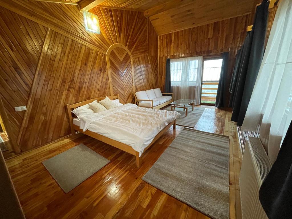 um quarto com uma cama e uma cadeira num quarto em Vila Piramida em Sighetu Marmaţiei