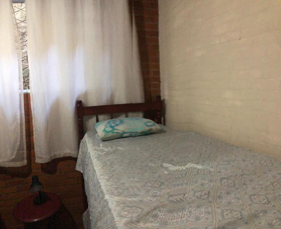 a small bed in a room with a window at Hostel dos Reis in Angra dos Reis