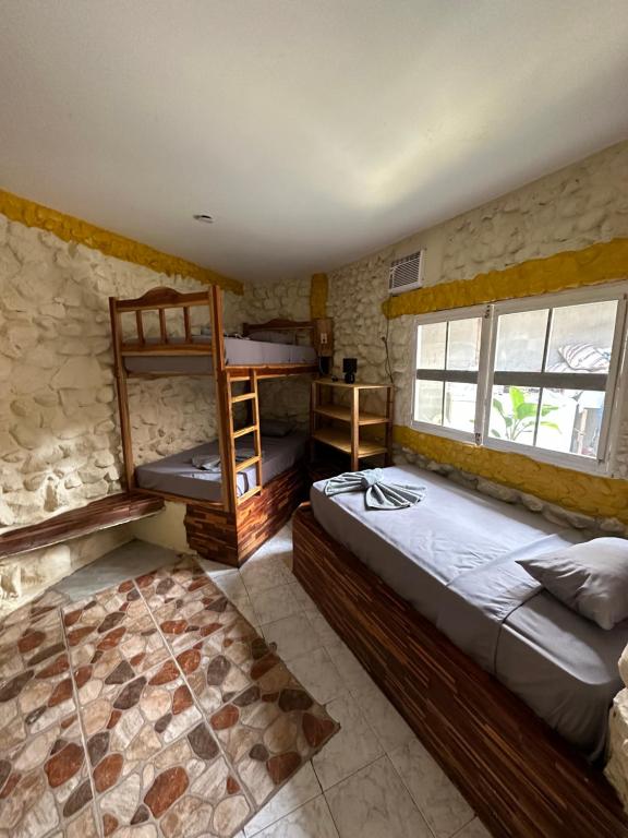 1 dormitorio con 2 literas y escalera en Malevo Suites - Apartments, en Ayampe