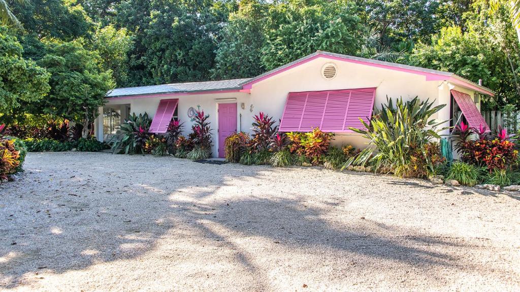 a house with pink doors and a gravel driveway at Little Bay Cottage in Islamorada