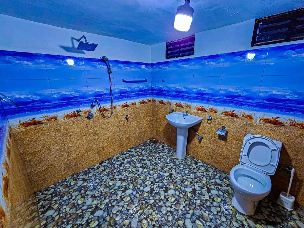 ein Badezimmer mit einem WC und einer Badewanne mit einem Aquarium in der Unterkunft Nice View Cottage in Udawalawe