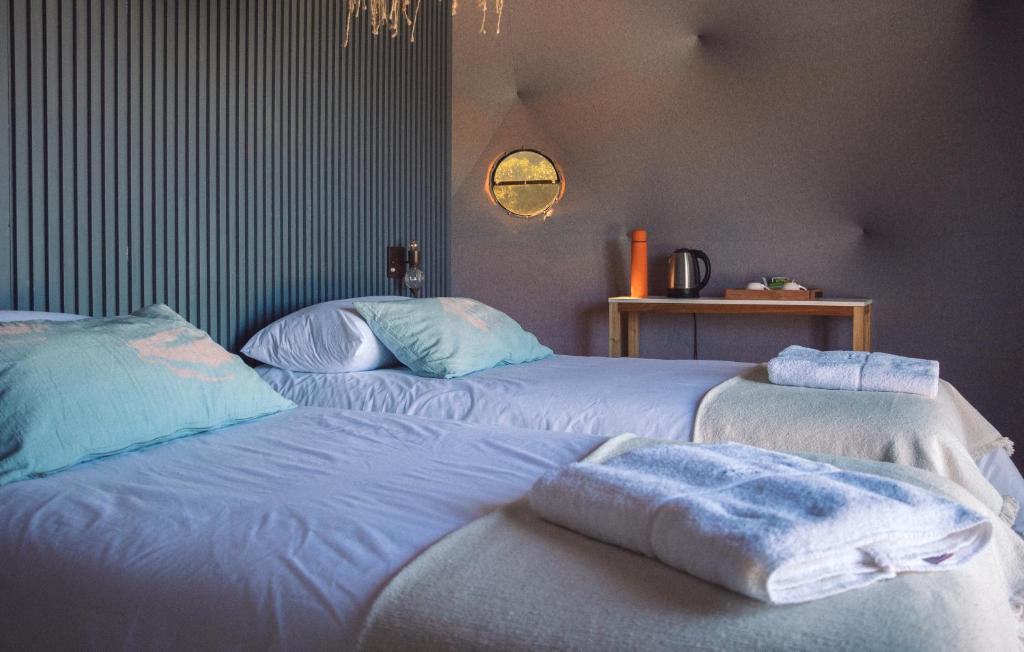 twee bedden in een kamer met handdoeken erop bij Domos Park in Mar de las Pampas