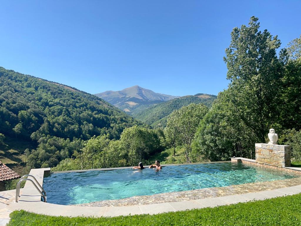 dos personas en una piscina con montañas en el fondo en Cabanya les Moreres, en Molló