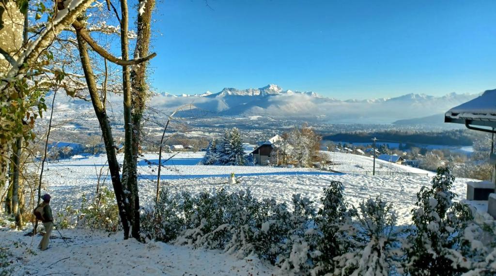 a person walking down a snow covered slope with mountains in the background at Charmant chalet 8p calme et vue sur montagnes in Verchères