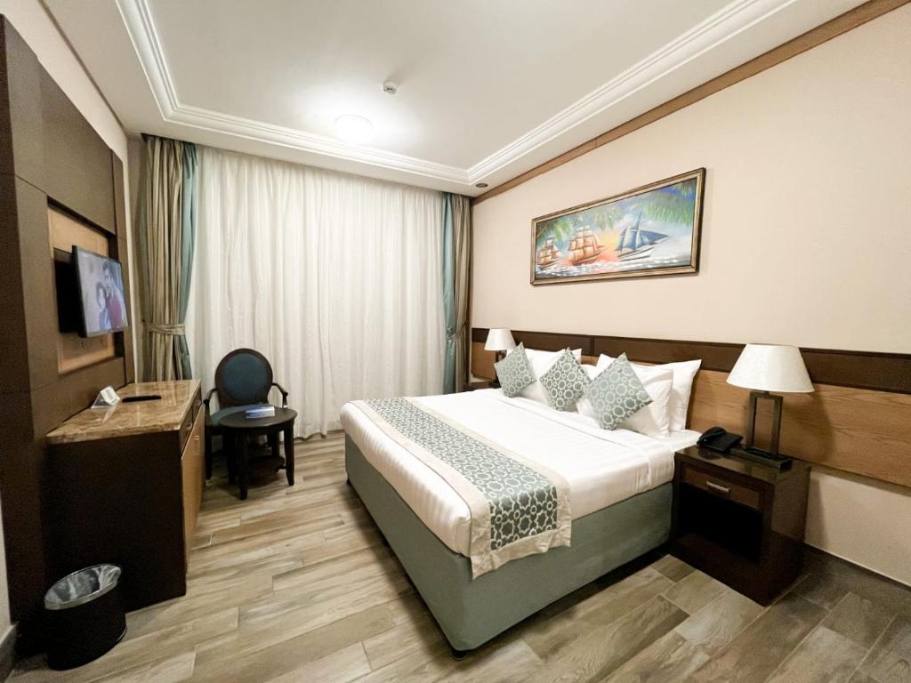 a hotel room with a bed and a desk at Afraa Hotel Al Aziziya in Makkah