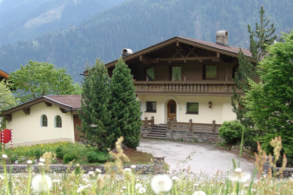 una grande casa in montagna con un cortile di Ferienhaus Kröll a Finkenberg