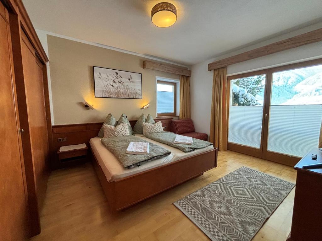 a bedroom with a bed and a large window at MB Apartment in Ramsau im Zillertal