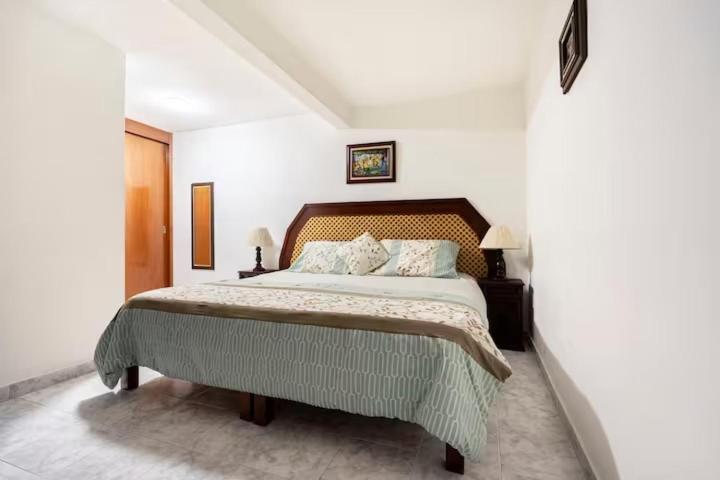 Casa Hogareña con Super Anfitrión في مدينة ميكسيكو: غرفة نوم بسرير كبير في غرفة بيضاء