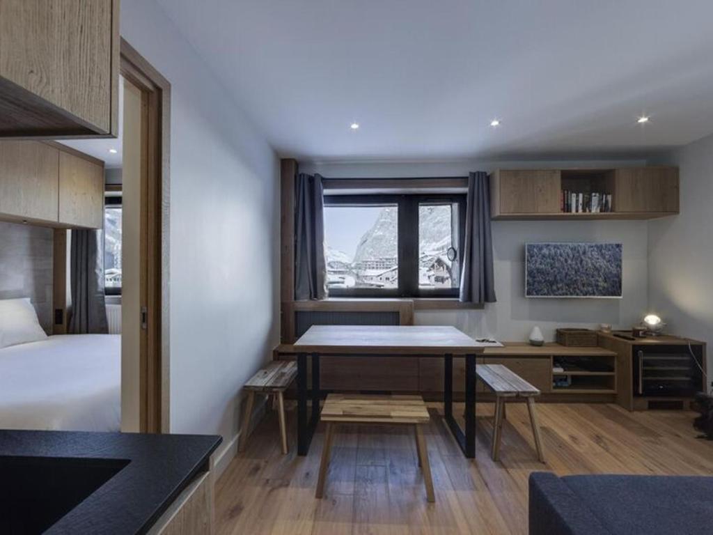 Cette chambre comprend une table, un lit et un bureau. dans l'établissement Charmant 3 Pièces avec Parking, Wifi, et Proche Remontées à Val d'Isère - FR-1-567-90, à Val dʼIsère
