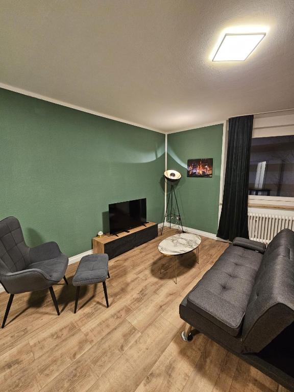 a living room with a couch and chairs and a television at Sweet Home - 5 - in Duisburg