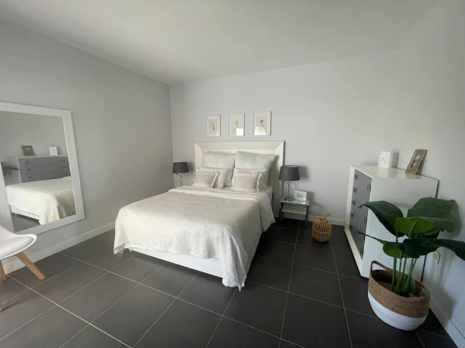 a bedroom with a white bed and a large mirror at Paraiso in Villaverde