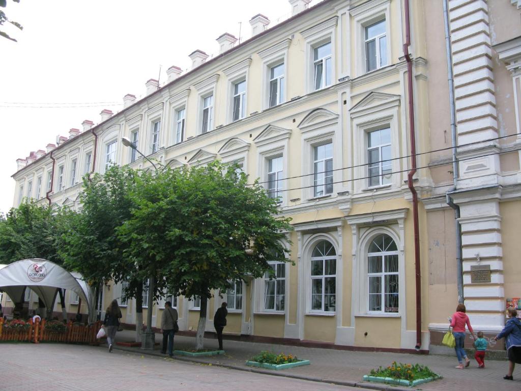 
a large building with a tree in front of it at Central Apartments Smolensk in Smolensk
