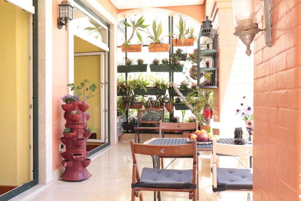 un patio con sillas y una mesa con plantas en LX Factory guest house en Lisboa