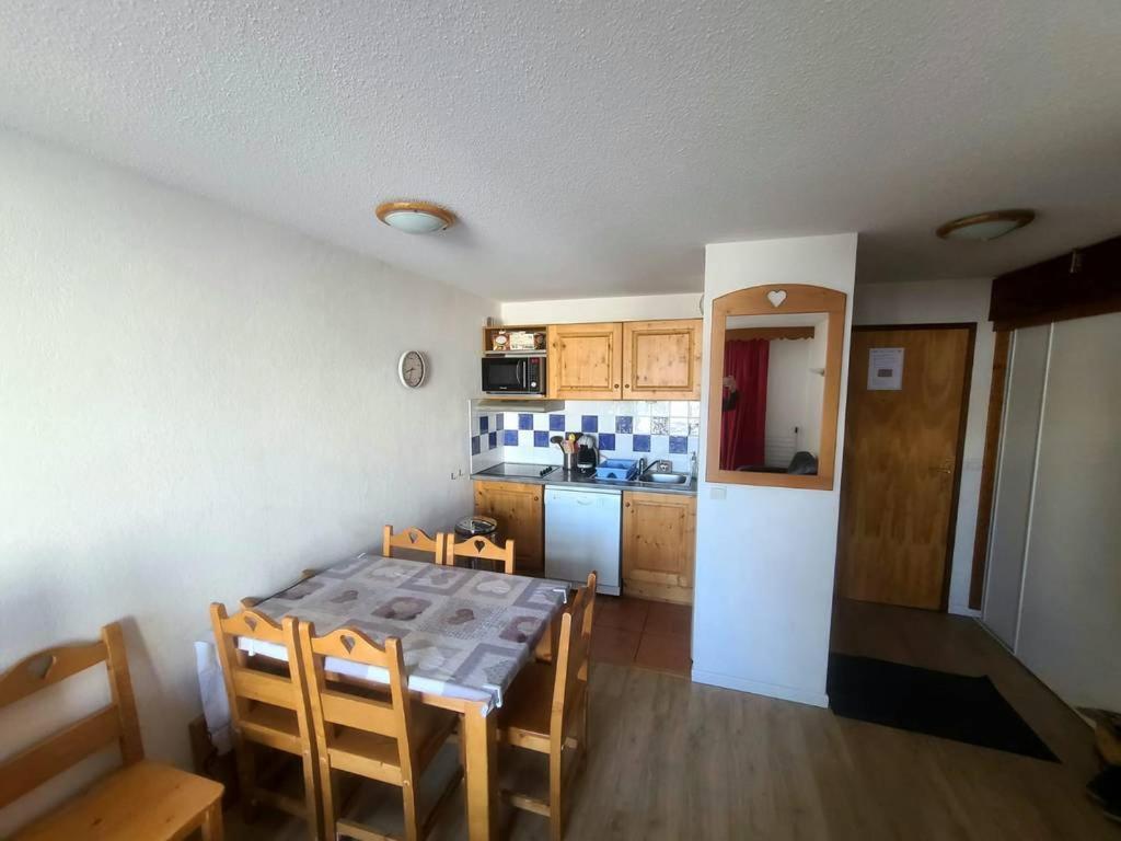 une cuisine avec une table et des chaises dans une pièce dans l'établissement Le balcon d'Orcières, à Orcières