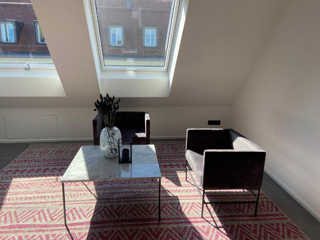 a living room with a couch and a table and a window at Suite One Löwengrube in Munich