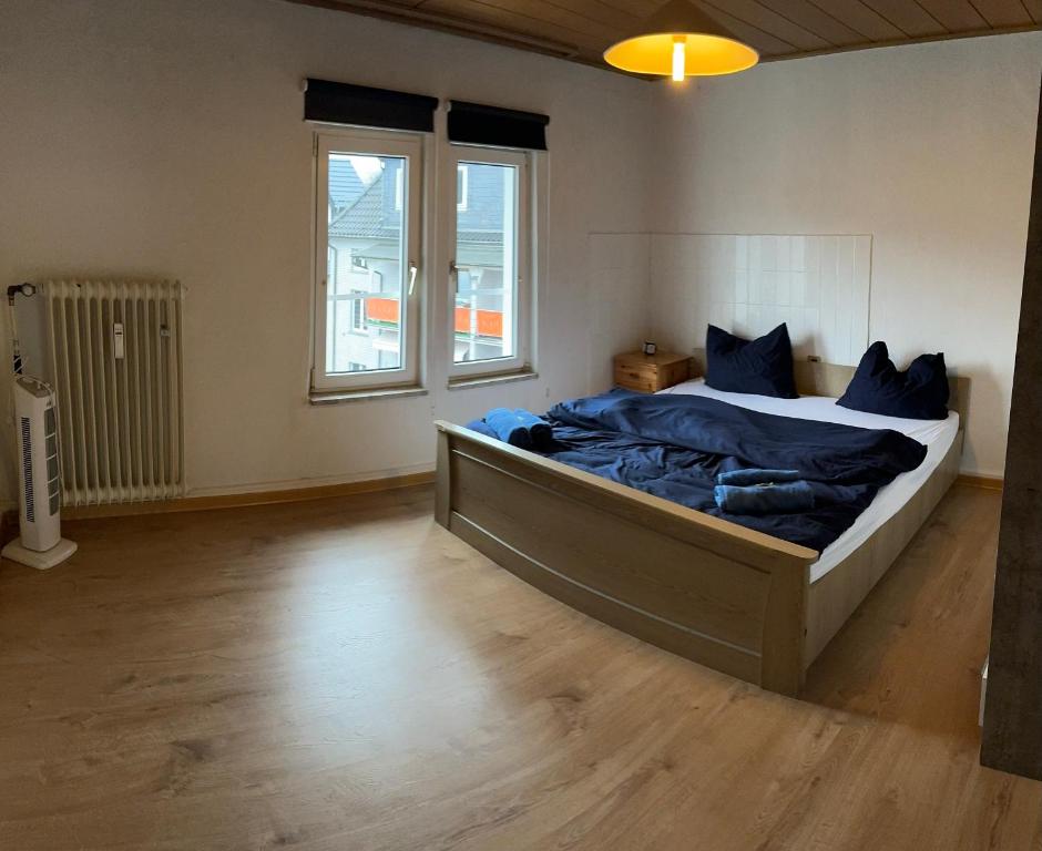 a bedroom with a large bed with blue sheets at Moderne Wohnung im Zentrum und Alte Wohnung im Zentrum in Eitorf