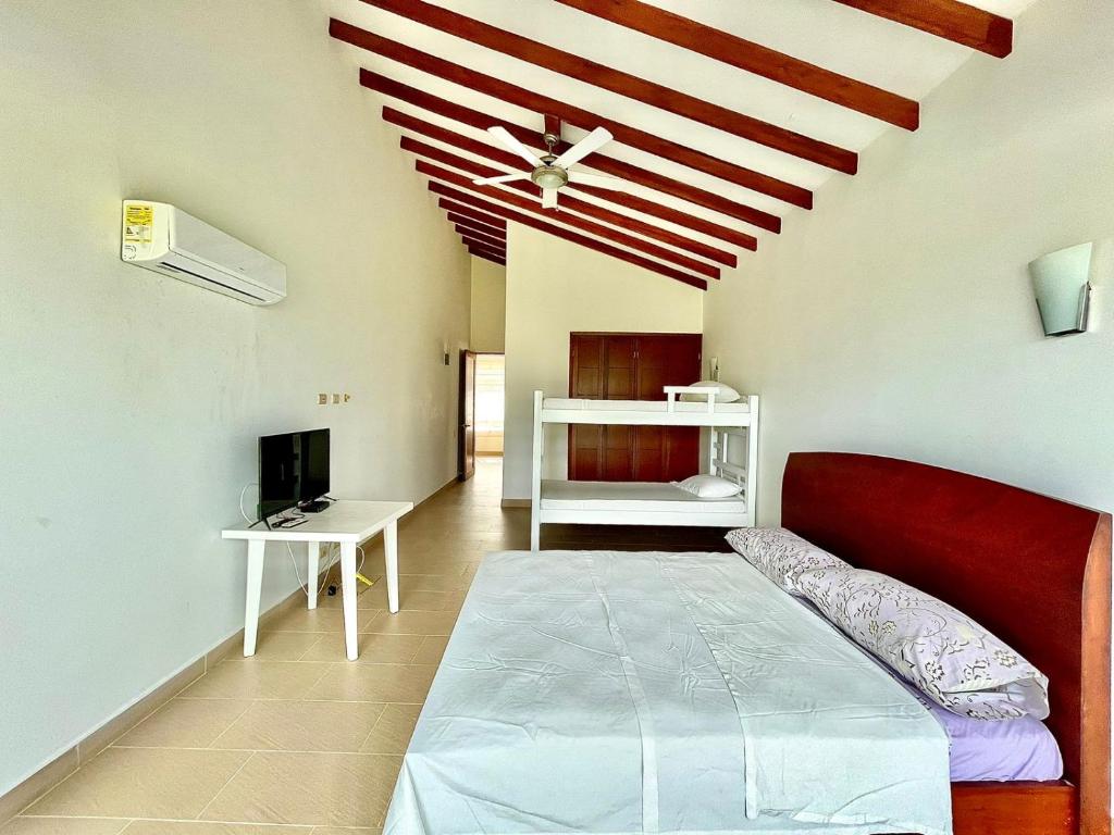 1 dormitorio con cama roja en una habitación con techo en Casa De Lujo Frente Al Mar 1, en Cartagena de Indias