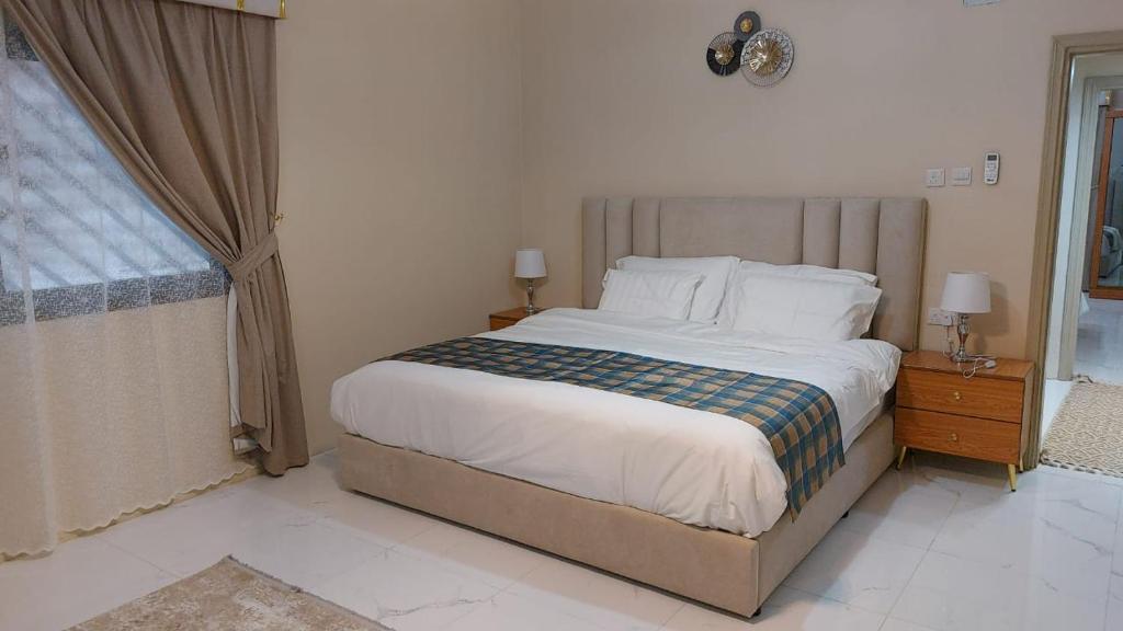 Un dormitorio con una cama grande y una ventana en شقة مفروشة ليالي العروبة متميزة مؤثثة بأثاث أنيق ومريح, en Riad