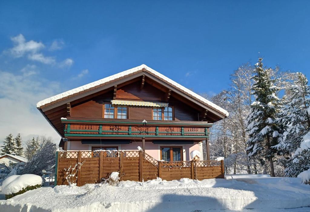 una cabaña de madera en la nieve con una valla en Appartement Panorama en Gröbming