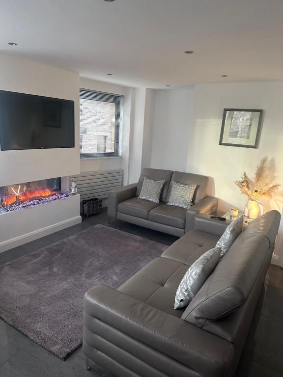 a living room with a couch and a fire place at LUXURY Apartment Belfast City Centre overlooking Custom House Sqaure in Belfast