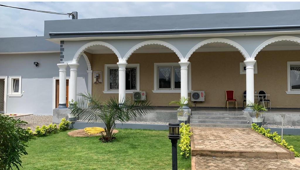 una casa con columnas blancas y un patio en Senam Haus, 