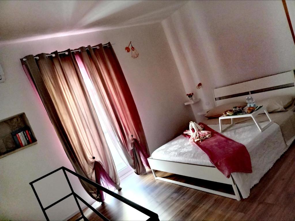 1 dormitorio con 1 cama con cortina roja en DIMORA PIETRAMORE, en Brindisi