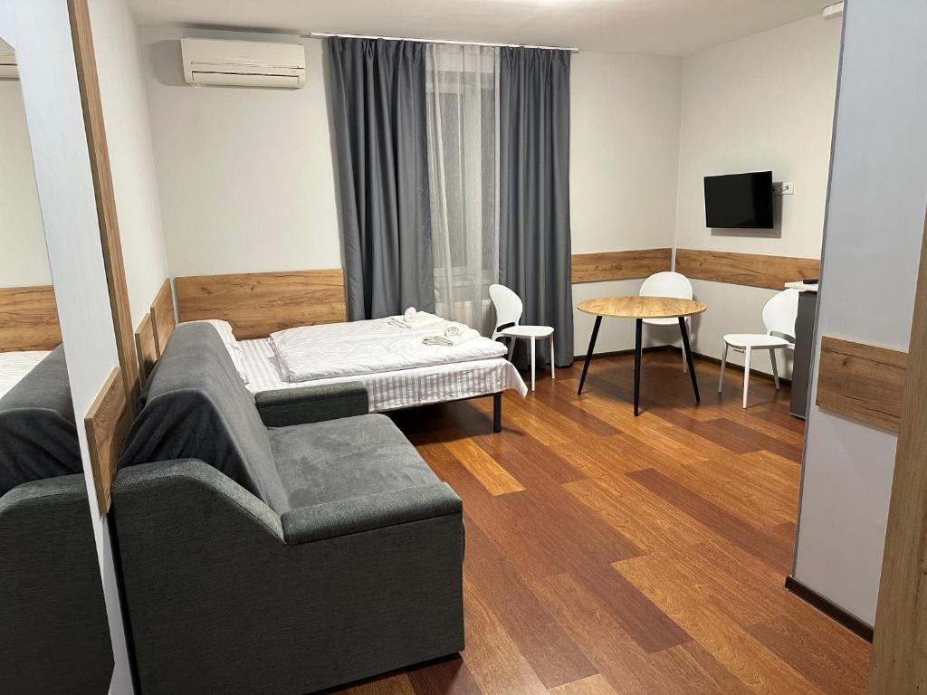 ein Hotelzimmer mit einem Bett und einem Tisch in der Unterkunft Modern Apartments Uzhgorod in Uschhorod