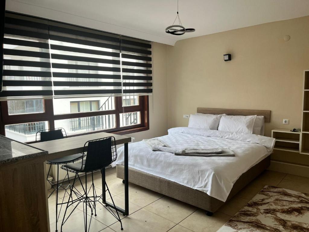 um quarto com uma cama, uma secretária e uma janela em BROWN em Ancara