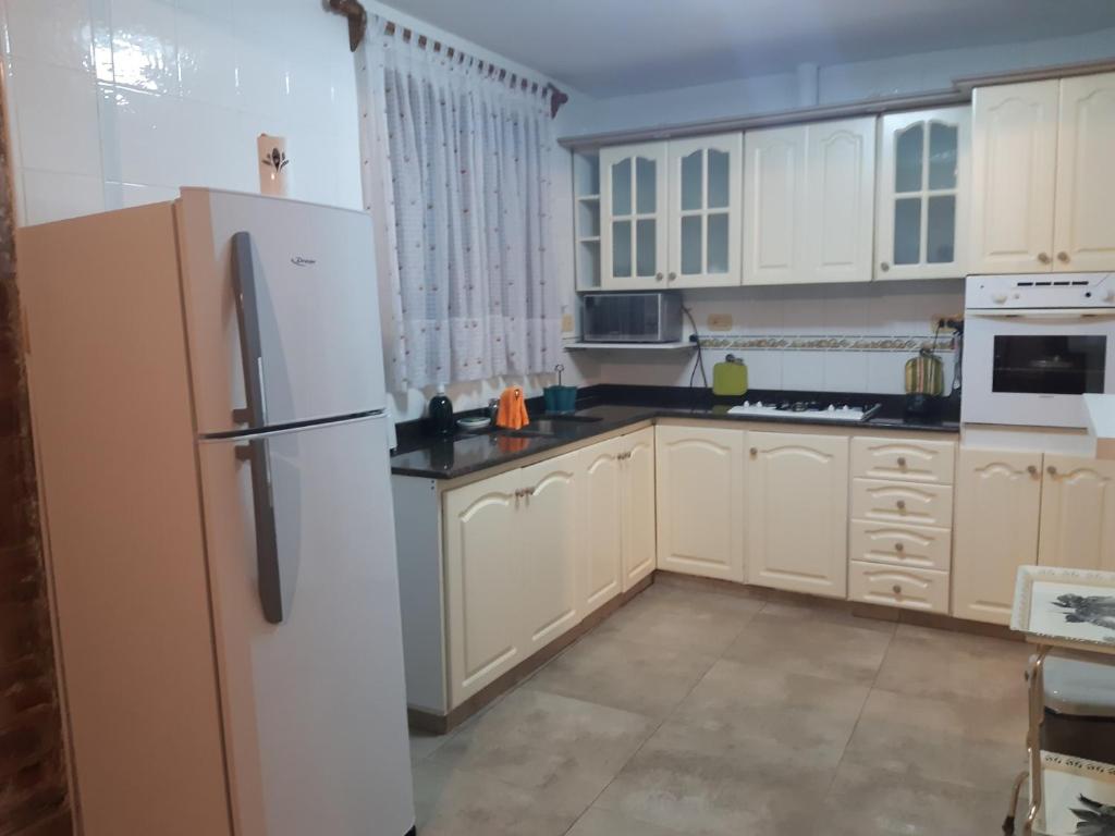 a kitchen with white cabinets and a refrigerator at DEPARTAMENTO PLANTA BAJA in Villa Nueva