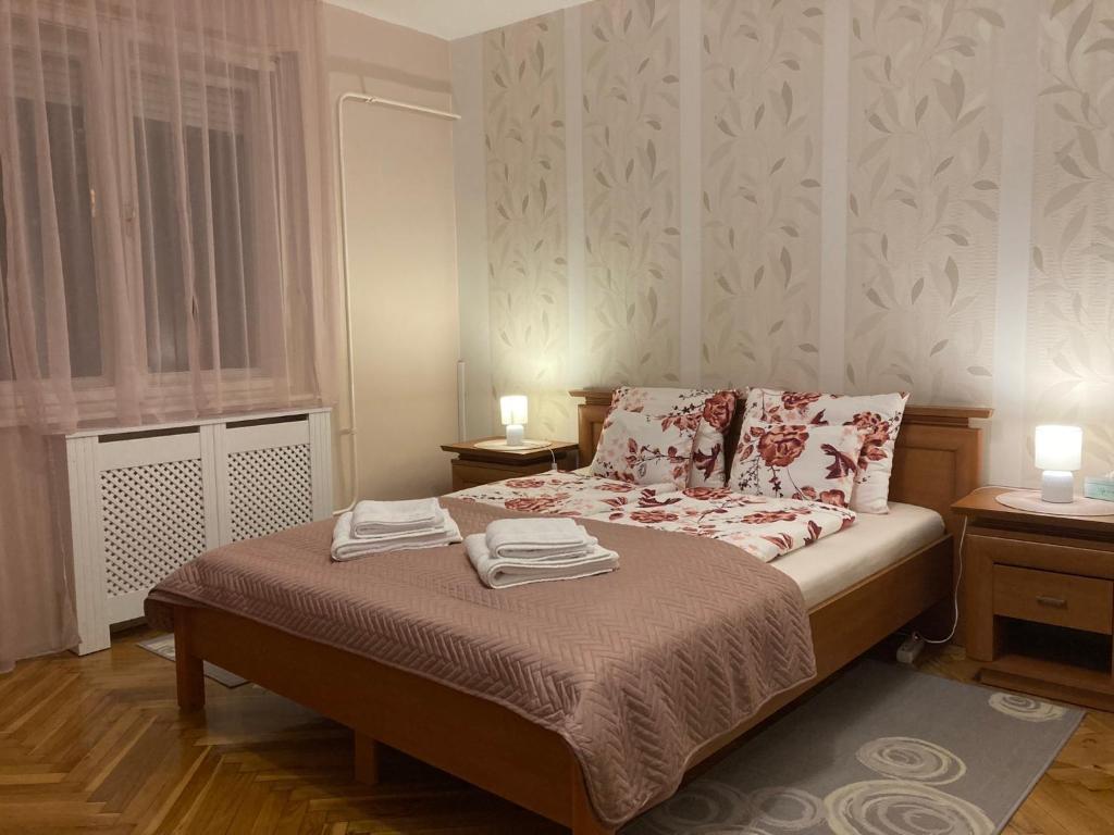 sypialnia z łóżkiem i dwoma ręcznikami na nim w obiekcie Fürdő Apartman w mieście Makó
