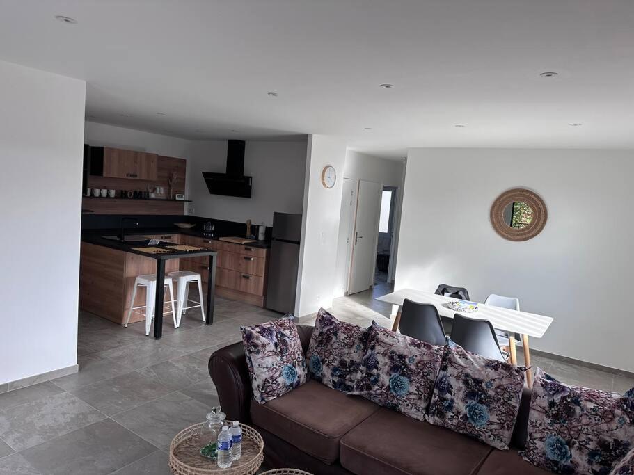 a living room with a couch and a kitchen at Chez sana in Saint-Dizier