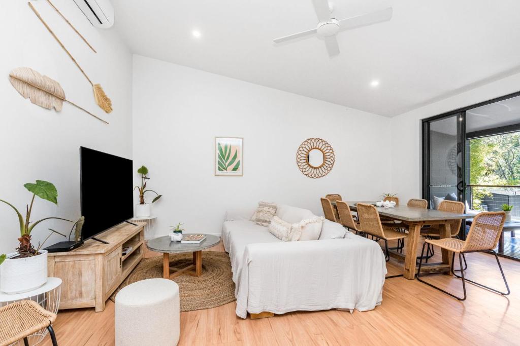 a living room with a white couch and a table at Light Filled Modern Specious Home, Pet friendly in a beautiful area of Byron Bay, short stroll to town in Byron Bay