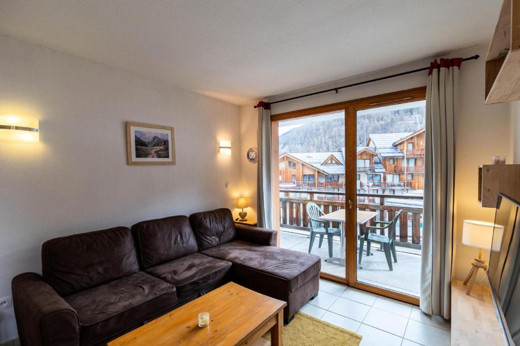 d'un salon avec un canapé et un balcon. dans l'établissement Résidence Le Balcon Des Airelles - Appartement au calme au coeur des Orres 1800 MAE-6364, aux Orres