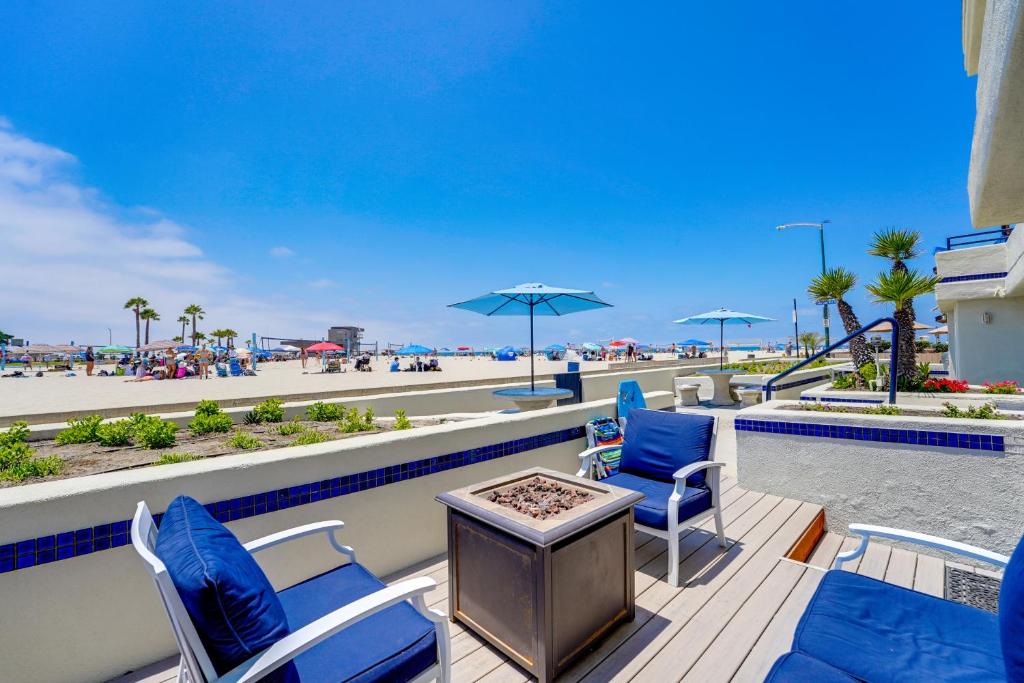 eine Terrasse mit Stühlen und einem Tisch mit Blick auf den Strand in der Unterkunft Oceanfront Condo with Front Patio, Gas Grill, Fire Pit - Prime Location!! in San Diego