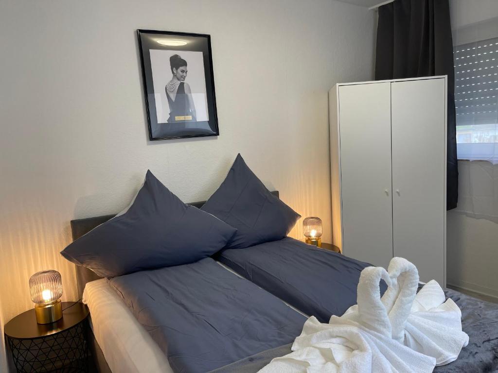 a bedroom with a bed with blue pillows at City Apartment am Rhein Bonn in Bonn