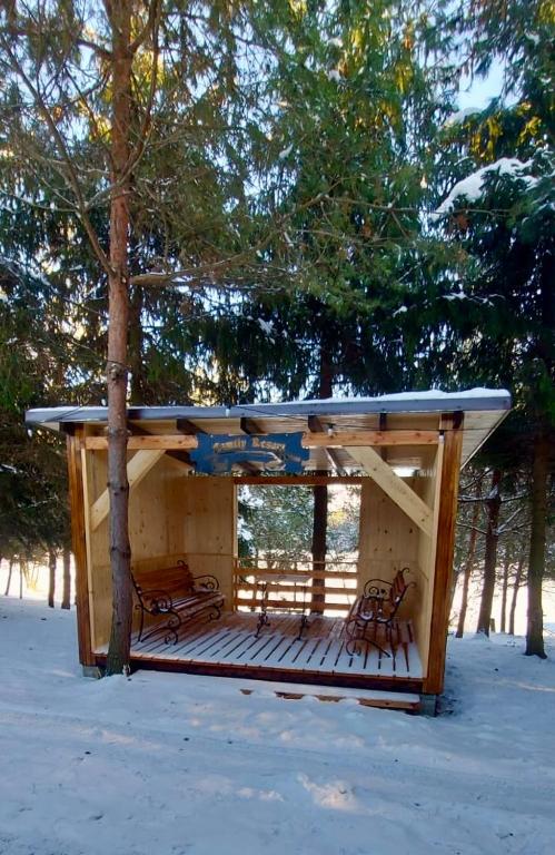a cabin with a roof in the snow at Family Resort in Mostiska