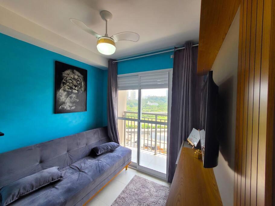 un salon bleu avec un canapé et un balcon dans l'établissement Ap 1 Quarto/varanda, Burle Marx!, à São Paulo