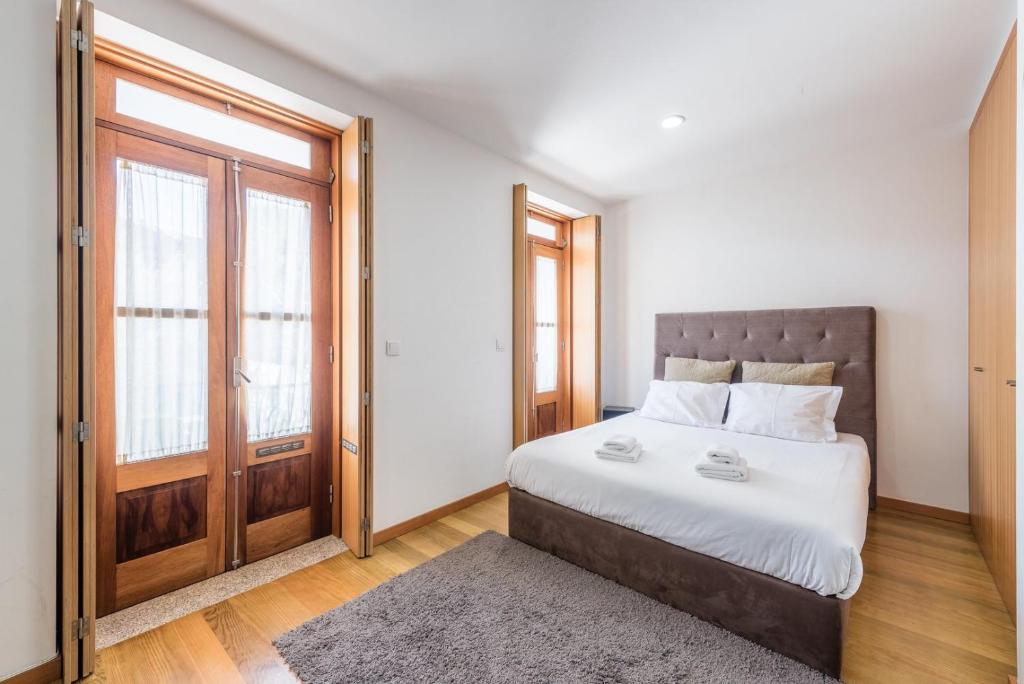 um quarto com uma cama grande e uma janela em GuestReady - Daisy Boutique no Porto