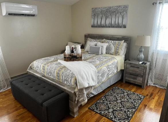 a bedroom with a bed with a laptop on it at Chic modern bedroom 5 mins from JFK in Locust Manor