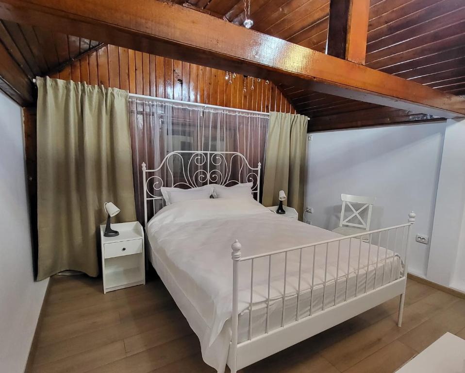 1 dormitorio con cama blanca y techo de madera en Adac Boutique Hotel, en Bucarest